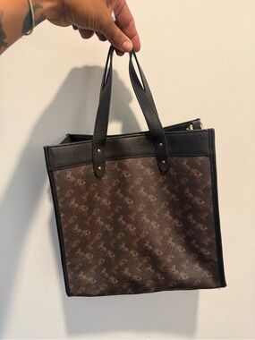 This is a Coach Field Tote in Truffle Black with a horse and carriage print